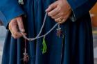 Woman's hands holding prayer beads, Ladakh, India