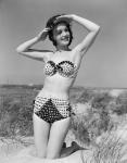 1950s Young Woman Kneeling In Grassy Sand