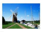Boat moored near a traditional windmill, River Ant, Norfolk Broads, Norfolk, England