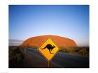 Kangaroo sign on a road with a rock formation in the background, Ayers Rock