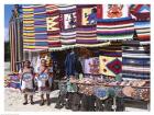 Two female vendors dressed in Mayan costumes displaying products