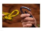 Close-up of human hands holding a carabiner and rope
