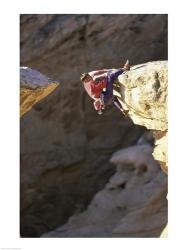 High Angle View of a Man hanging off of a Summit | Obraz na stenu